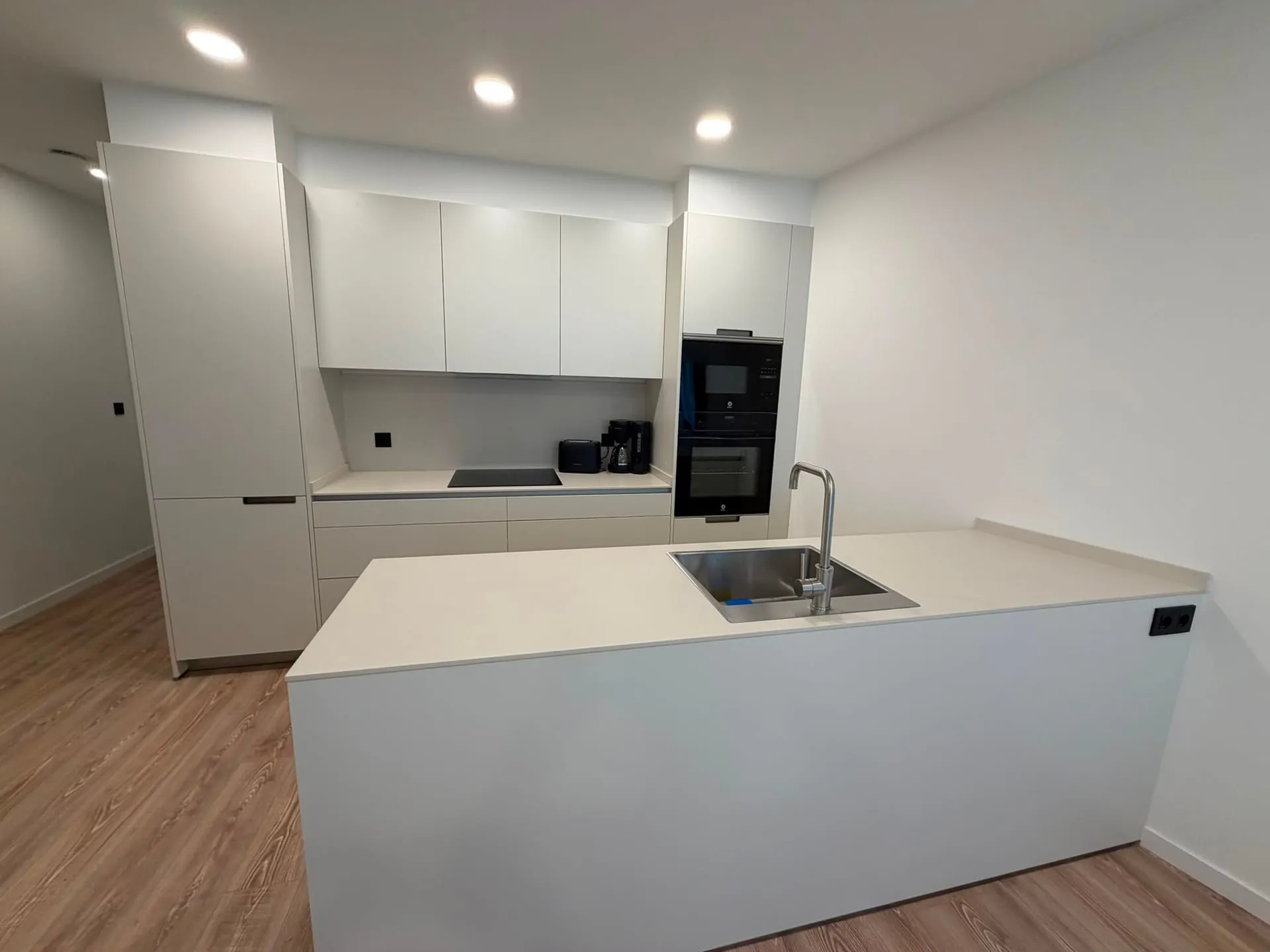 Cocina equipada con isla y horno en columna